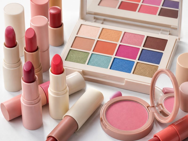 Unbranded lipsticks, an eyeshadow palette and a blusher compact on white